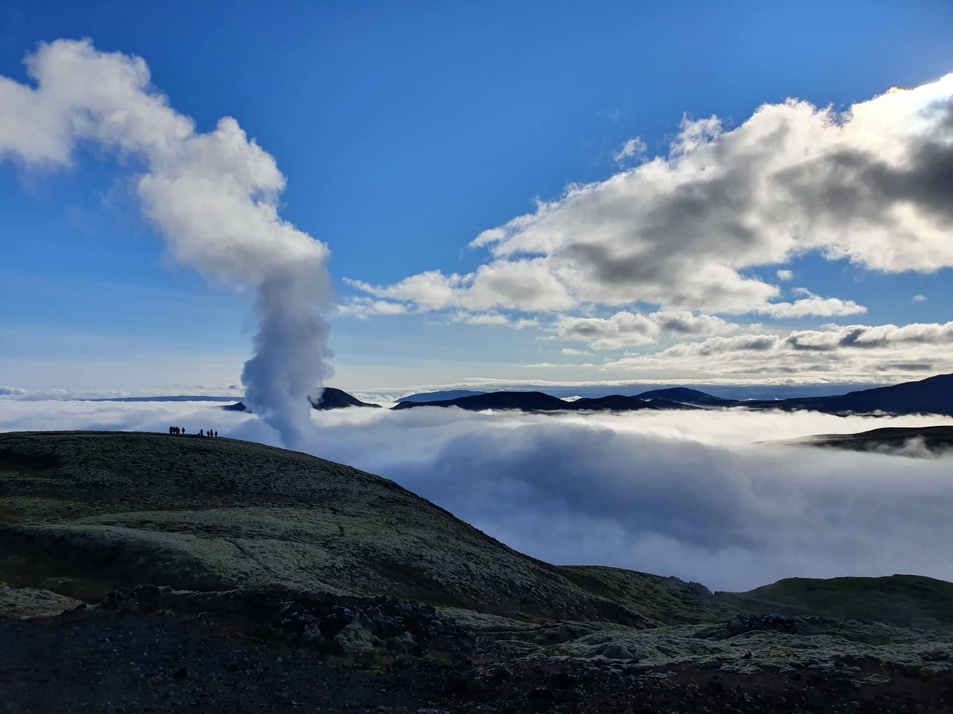 Geothermal steam rising above a sea of clouds over Iceland's volcanic mountains