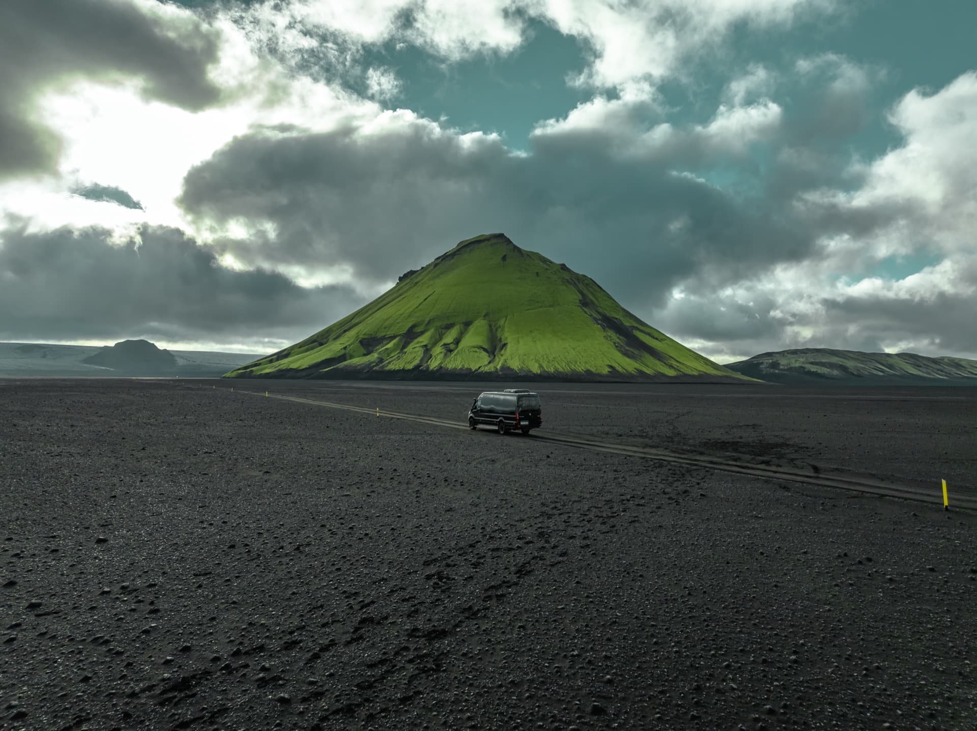 One Luxury Mercedes-Benz Sprinter 4x4 crossing the black sands beneath Mælifell volcano in the Icelandic highlands