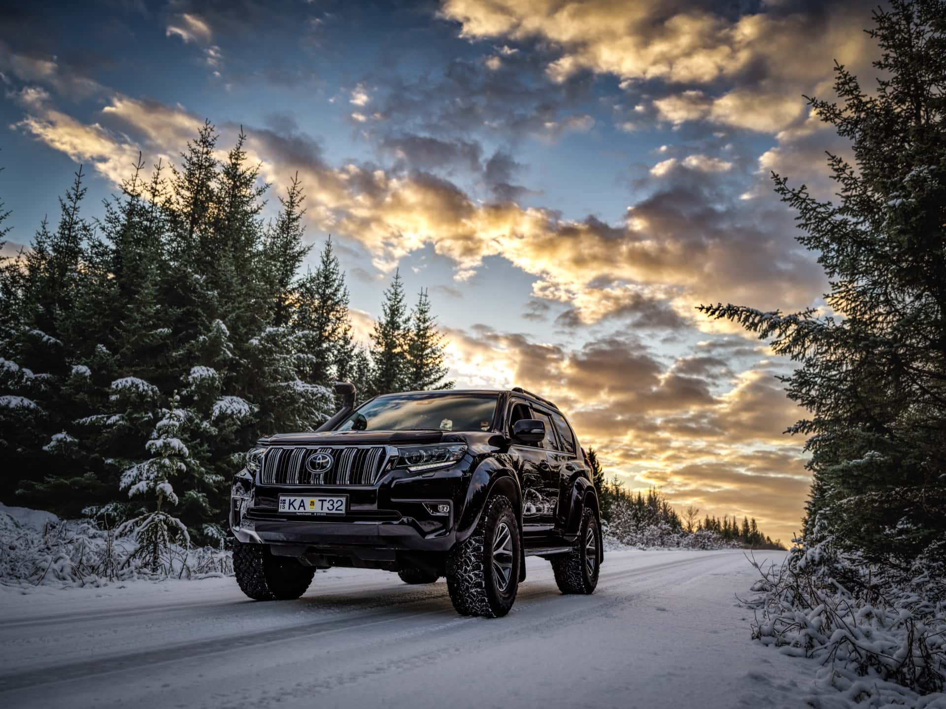 One Luxury modified Toyota Land Cruiser on a snow-covered forest road at sunset in Iceland