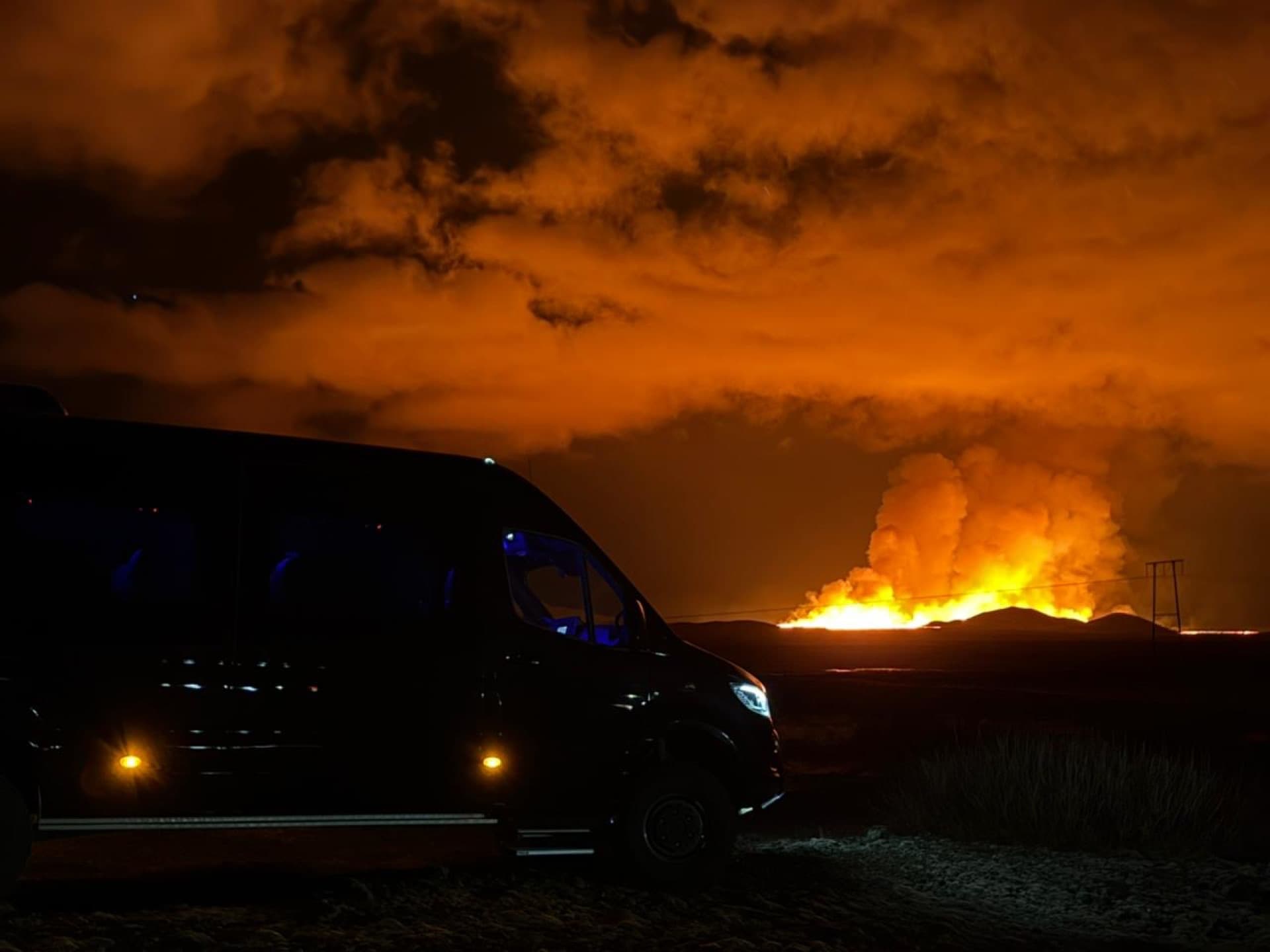 One Luxury Mercedes-Benz Sprinter in front of the glowing Sundhnúkur volcanic eruption on the Reykjanes peninsula at night